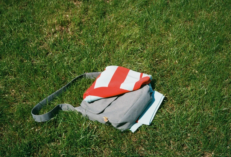 the grey bag is laying on top of a cloth