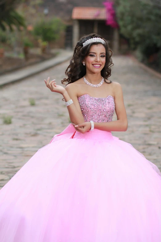 a woman wearing a ball gown holding up her hand