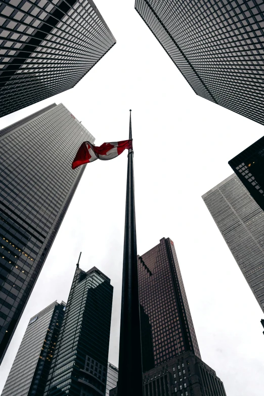 a group of tall buildings near each other with a flag flying high up