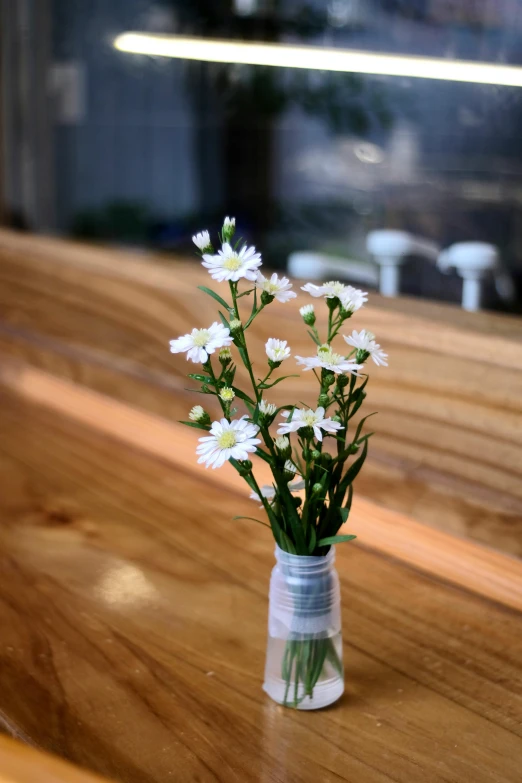 flowers in a bottle sitting on the countertop