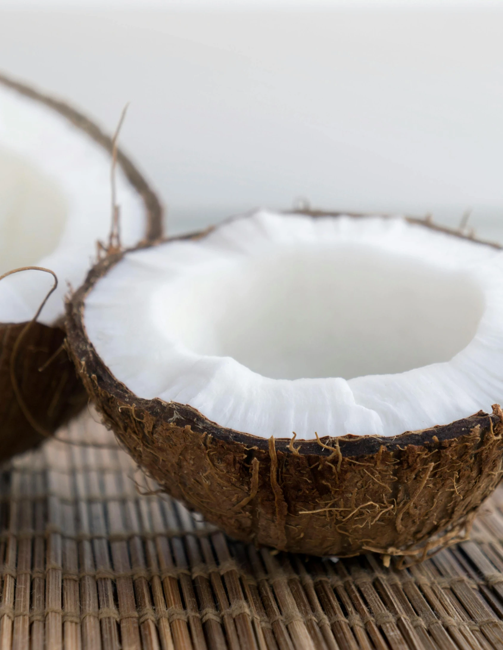 a whole coconut sitting next to another half