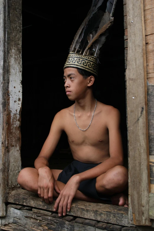 a man sitting in the window of a wooden building