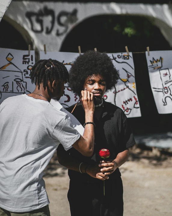 two men stand outside with signs hanging from a clothesline