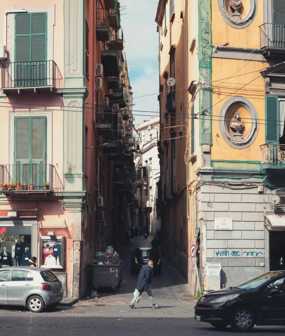 some people on a street with buildings and cars