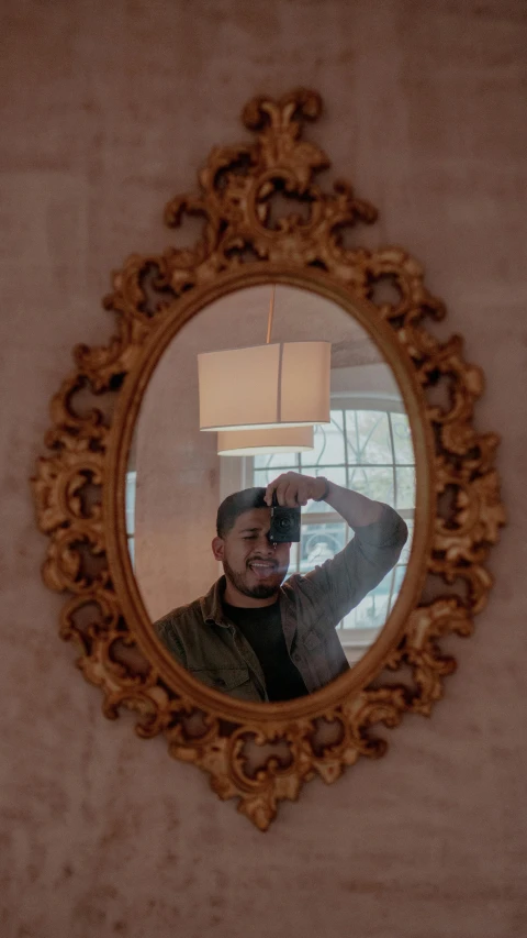 man taking picture through circular mirror with lamp