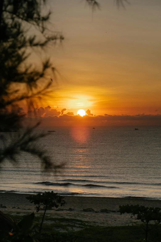 the sun is setting on the ocean over the water