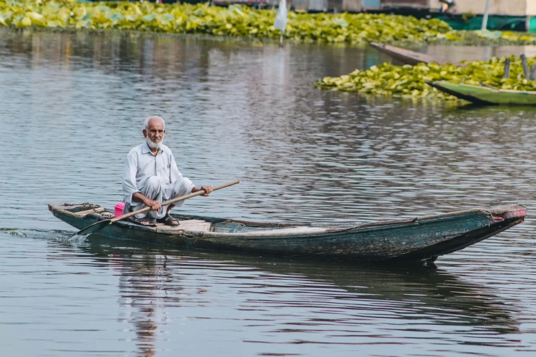 a man is sitting in the water with two oars