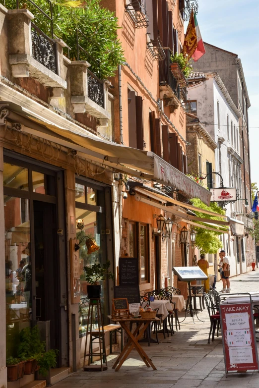 an empty street has tables, chairs, and windows