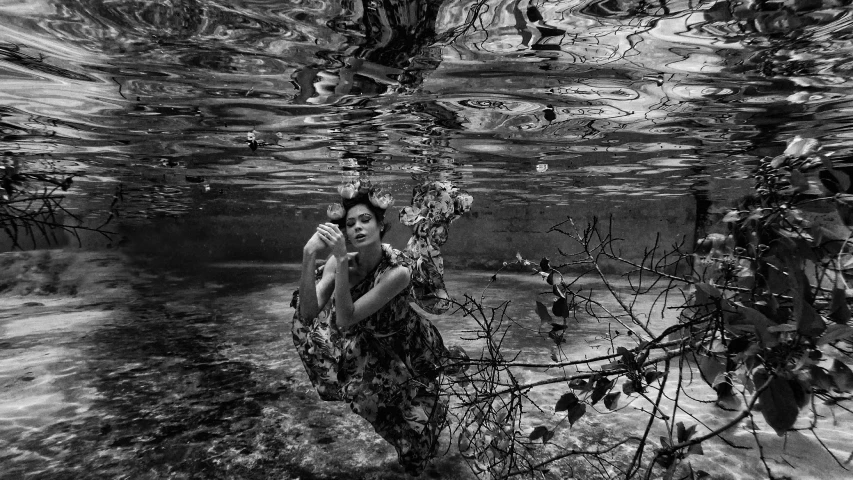 a woman in a dress stands on the bottom of a waterfall