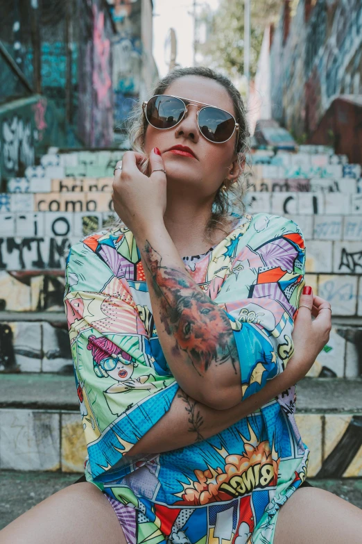 a woman sitting on steps wearing sunglasses and holding her chin under one arm