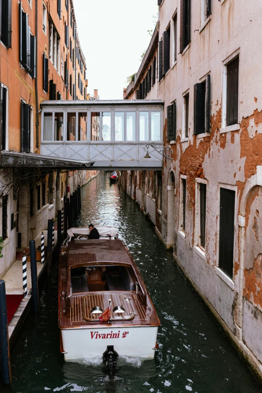 a long boat in a narrow canal between two buildings