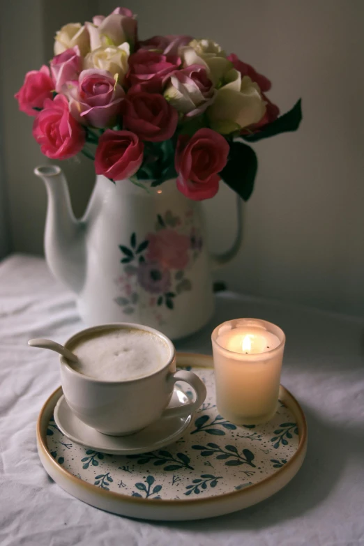 the coffee mug is next to a lit candle on a table