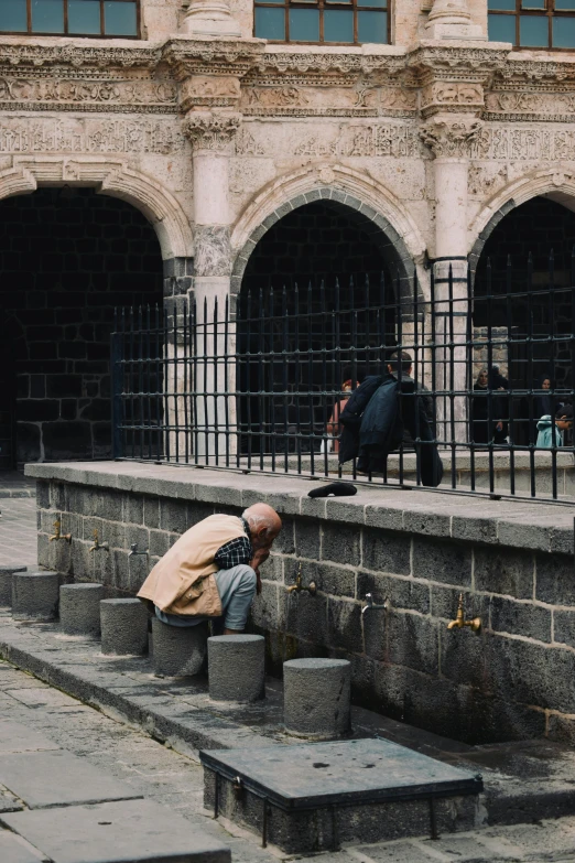 an old man is standing next to a cement wall