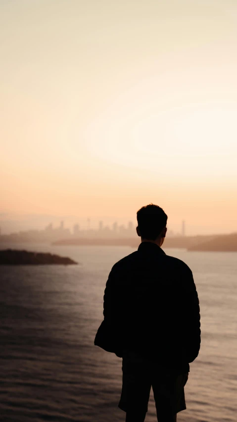 a person standing near a body of water looking out at the ocean