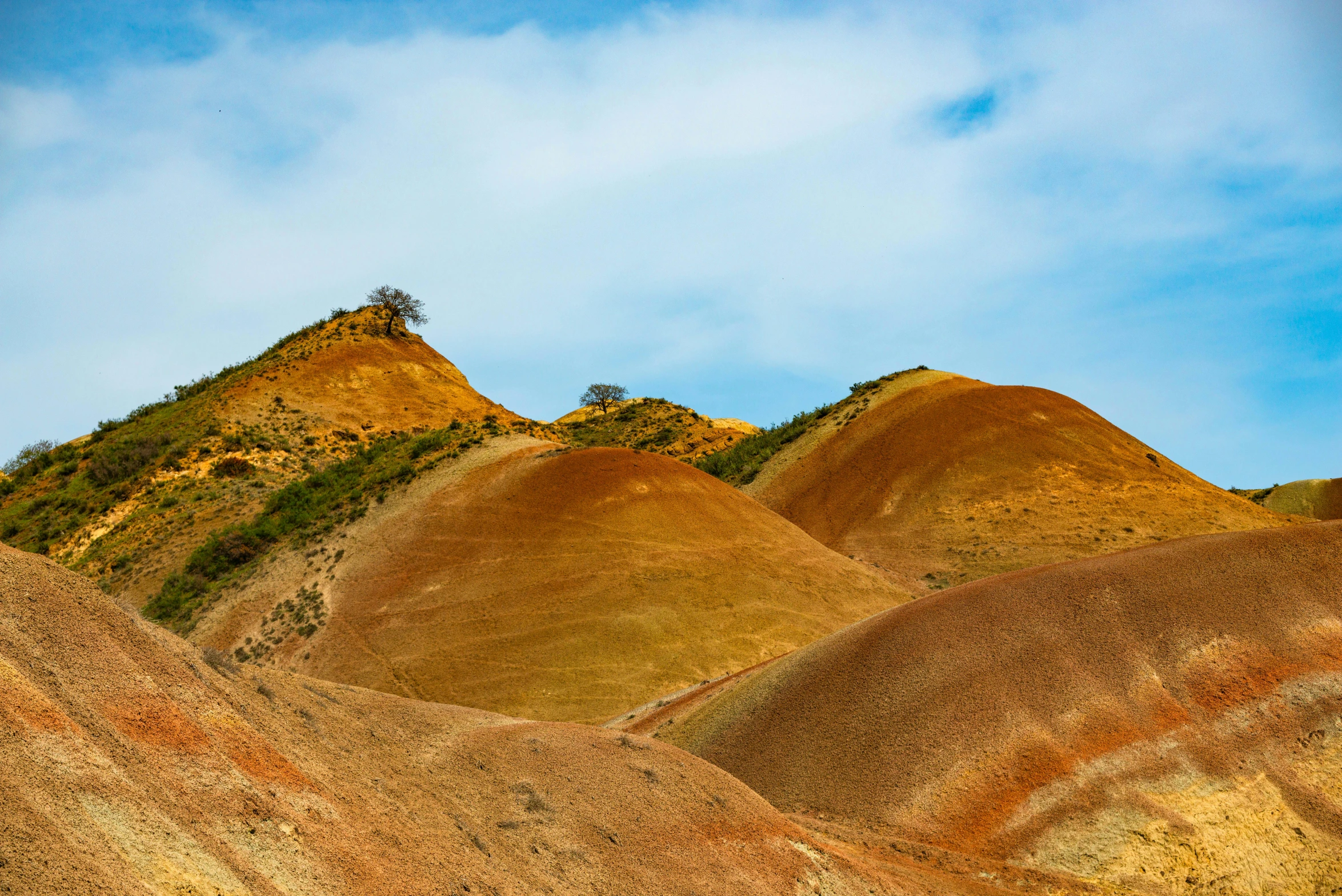 large hill covered in dirt on top of a blue sky