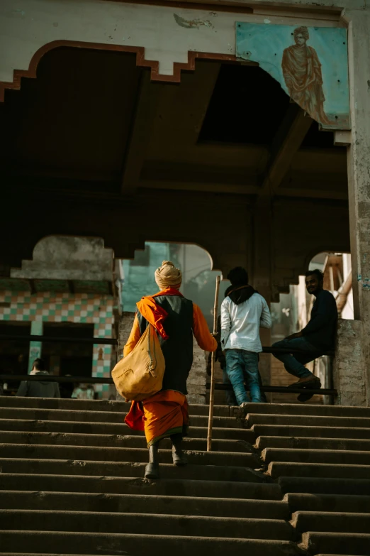 a woman in an orange sari is going up some stairs