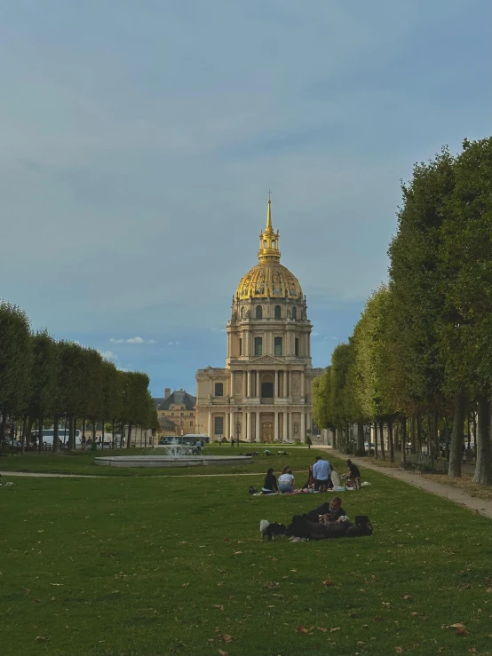 a couple laying on the grass in front of a building