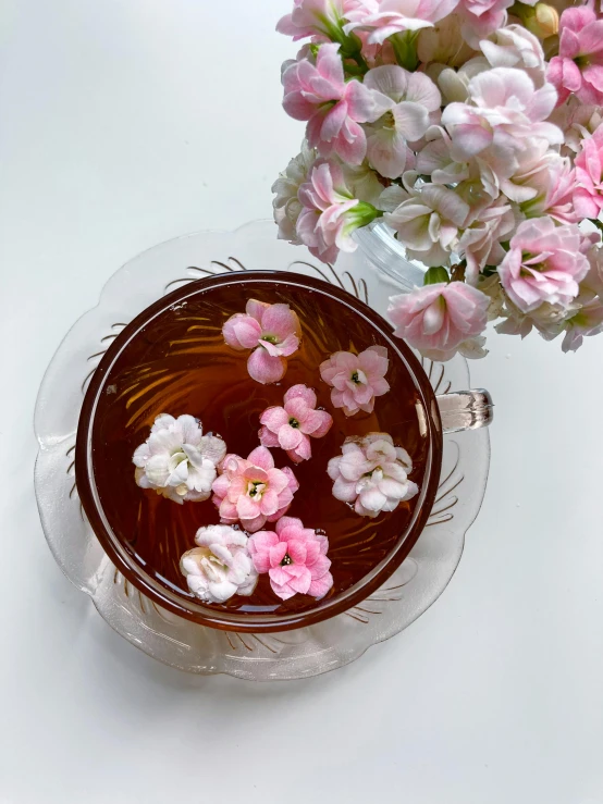 a glass dish with water and flower on a table