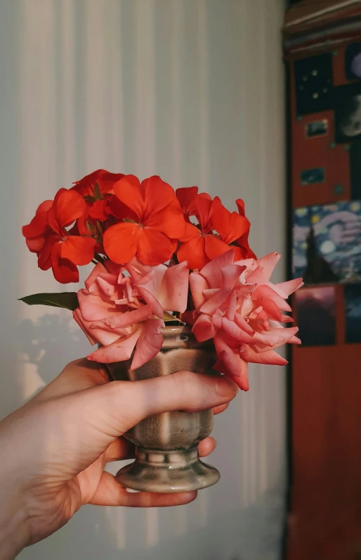 a person holding an elegant vase with flowers in it