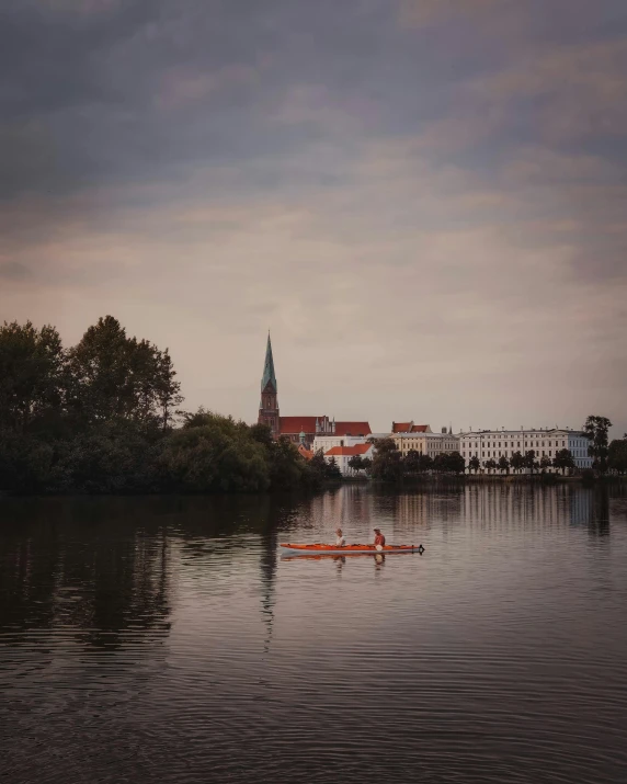 an orange canoe with a view of a building on the other side