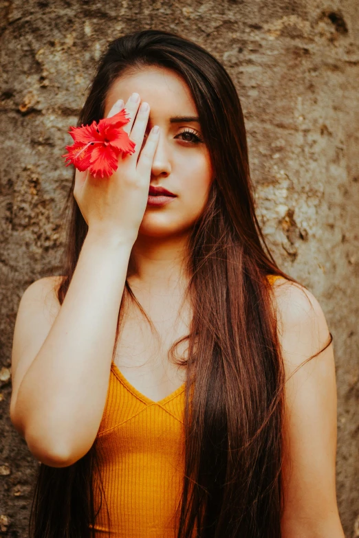 the woman is holding the flower to her face