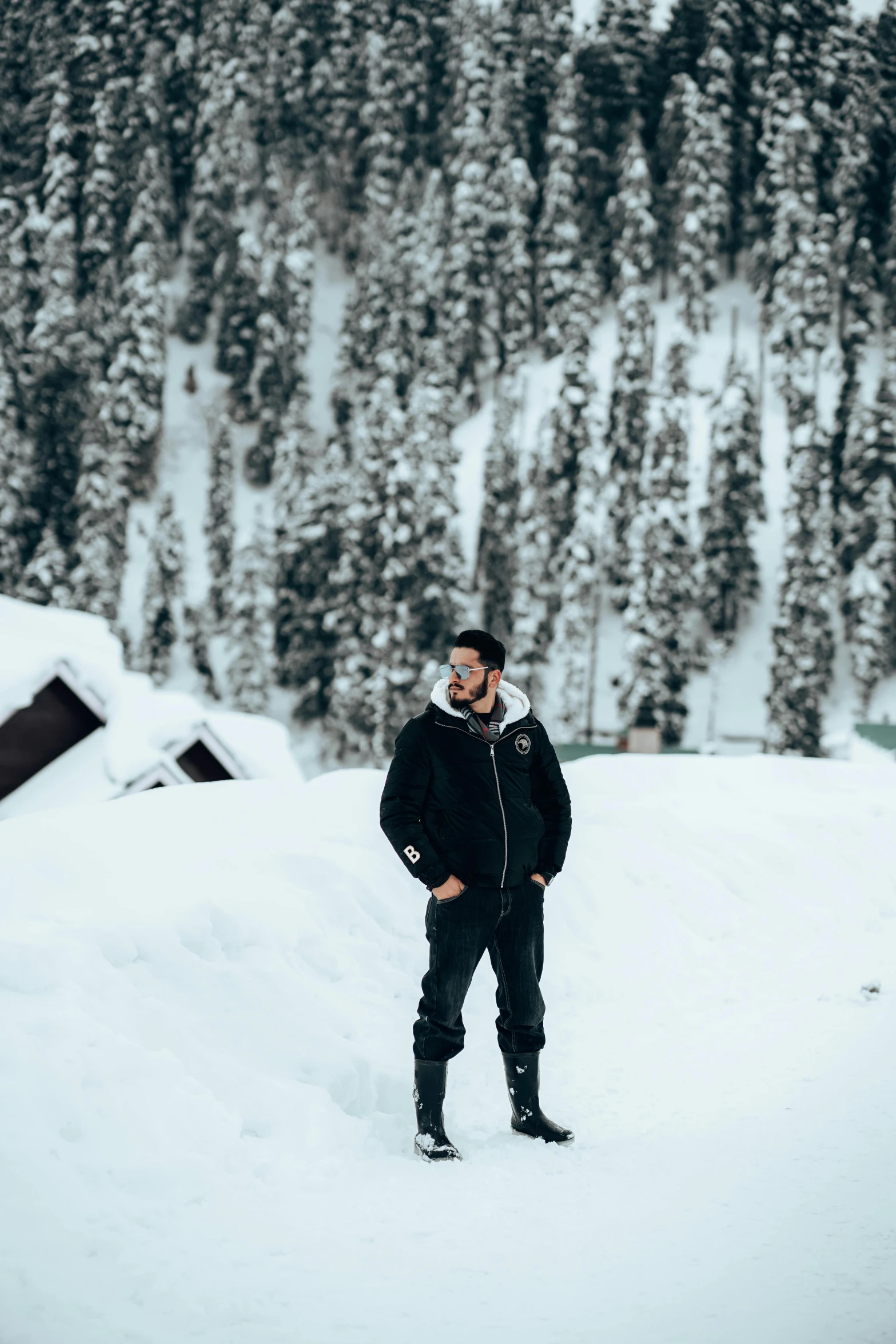 a man is standing in the snow near the trees