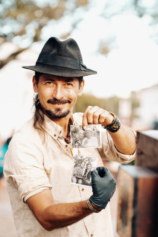 a man is holding playing cards by the street