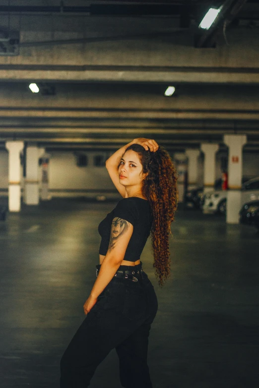 a woman posing in an empty parking garage