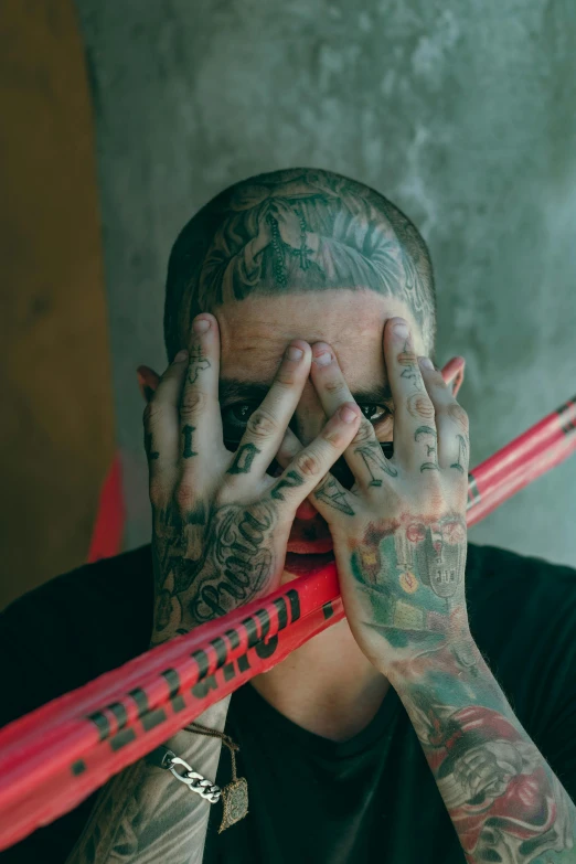 man holding baseball bat up to his face