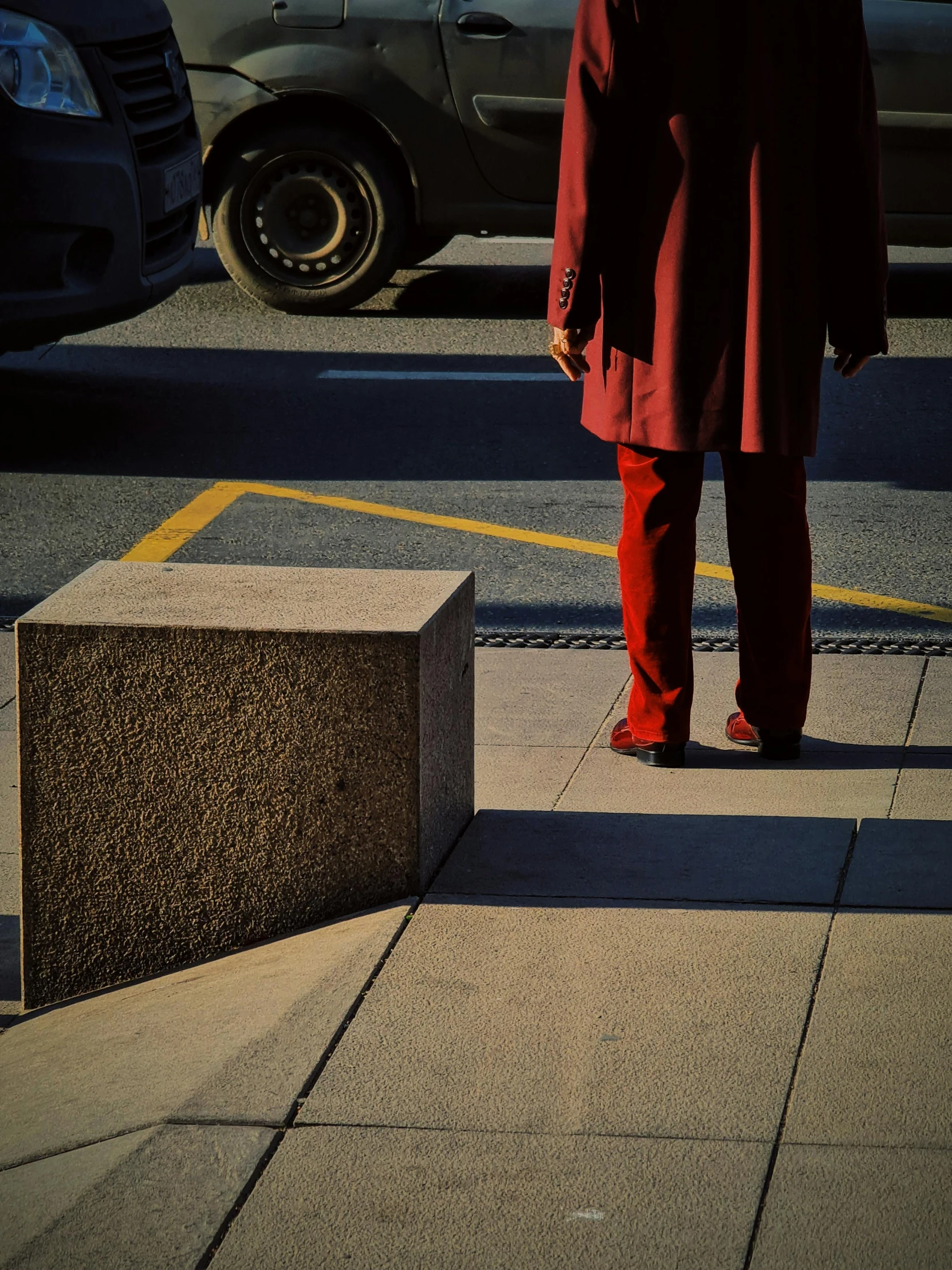 man in red jacket standing next to small building