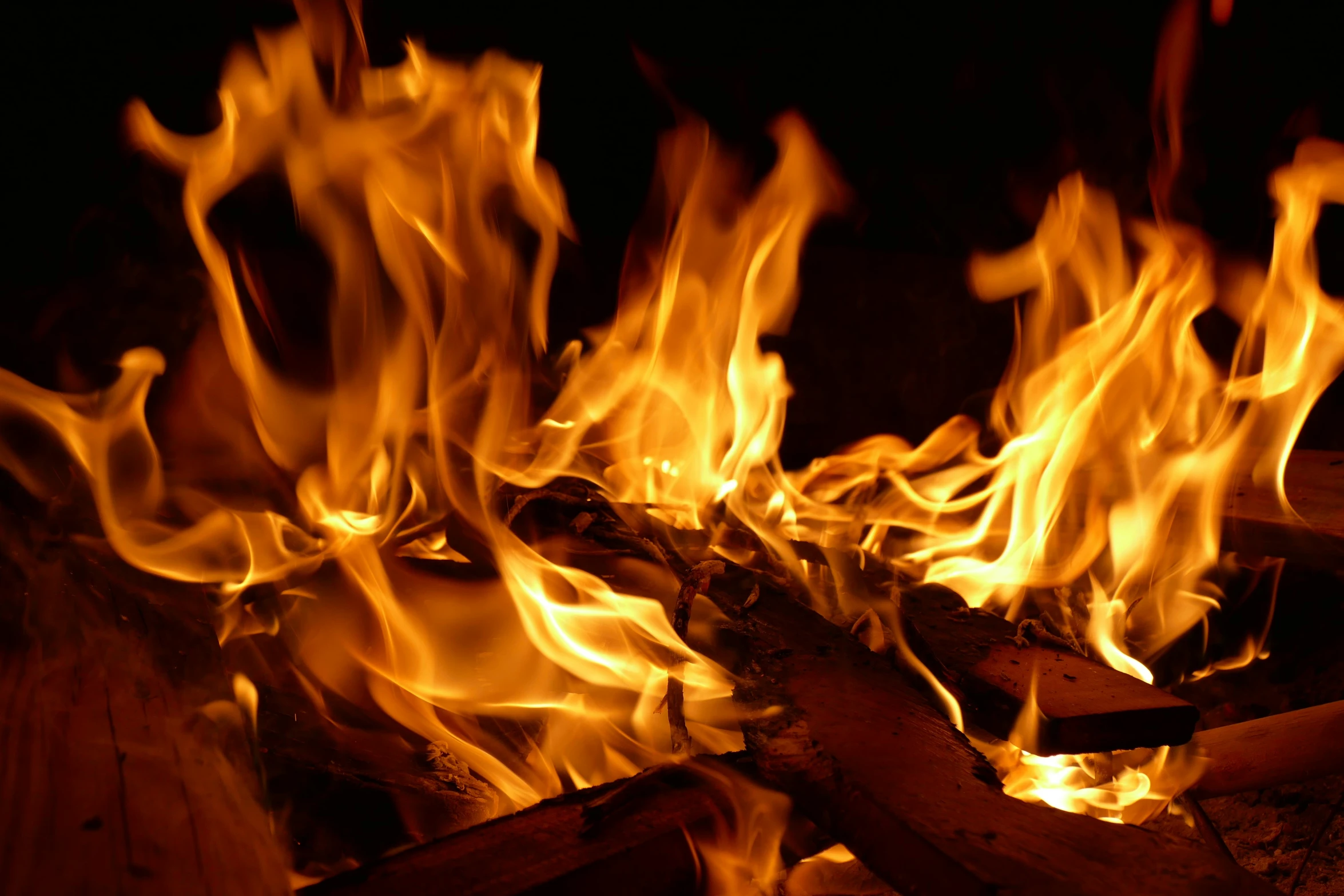 the  fire burns in a wooden burning pit
