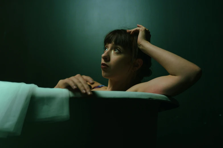 a woman in the foreground, holding a white towel in her hand, looks over a rail