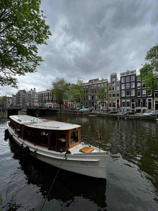 a small boat traveling down the river on a cloudy day