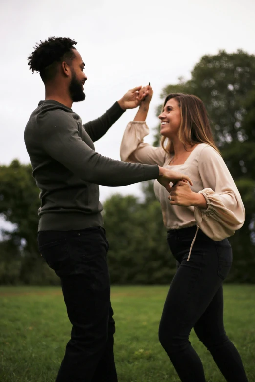 the couple is playing with each other on the grass