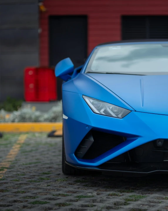 a close up of a blue sports car parked on the street