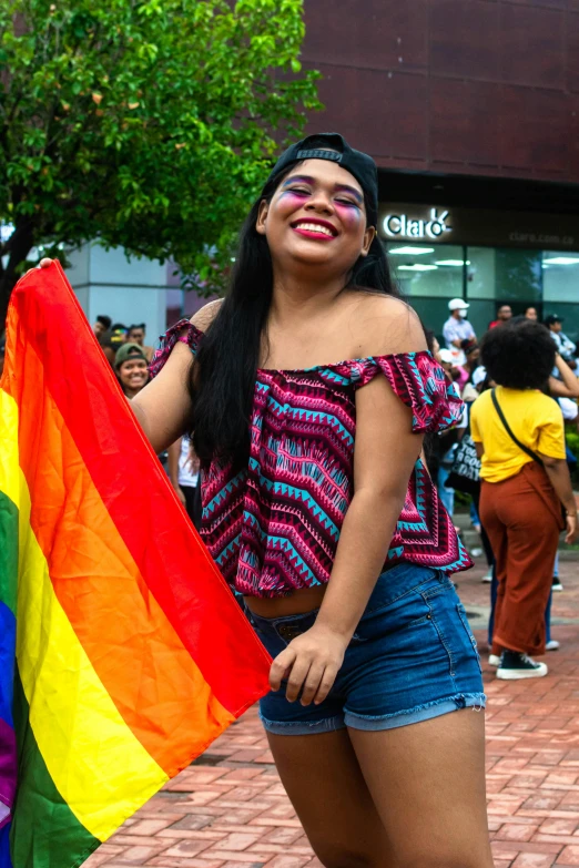 a woman wearing a rainbow shirt with eyes painted on