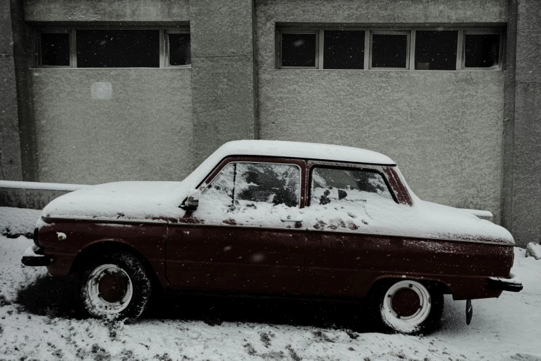 the old car is covered in snow on the side of the road