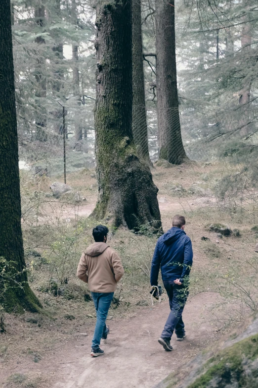 two men walking down a path in the woods