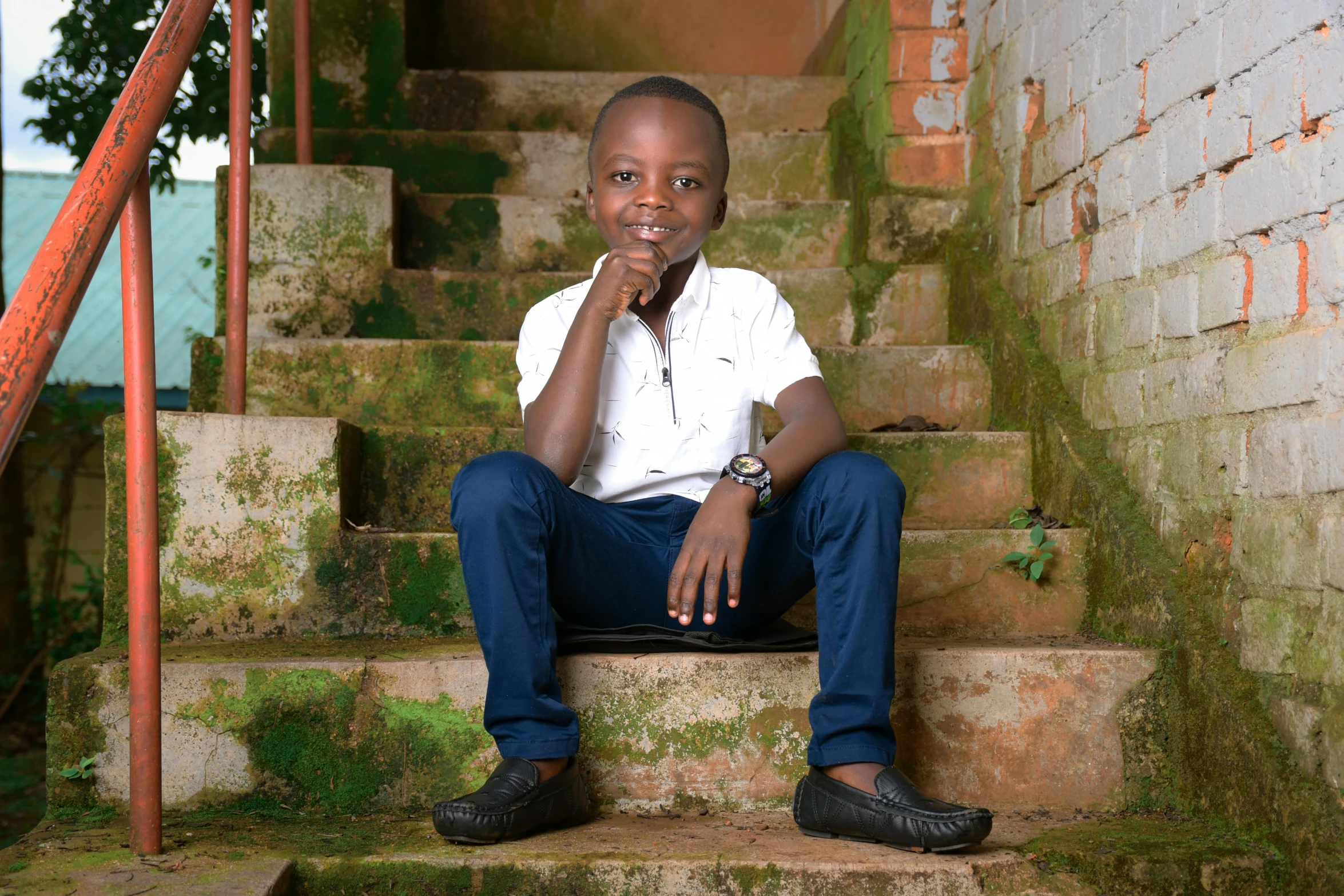 a man sits on steps while holding his chin