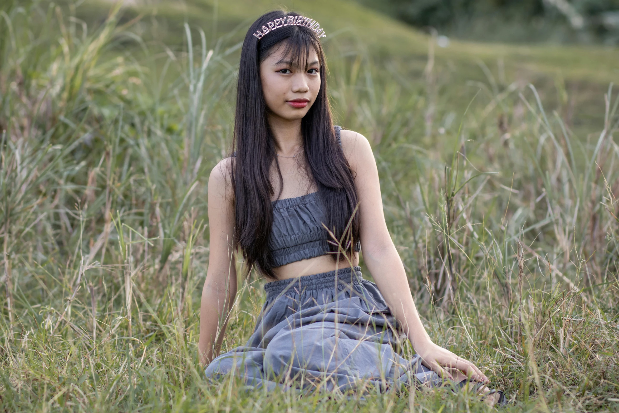 a young woman posing in a grassy field