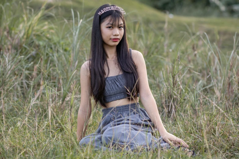 a young woman posing in a grassy field