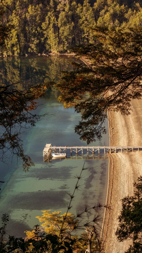 a white boat docked at the shore of a lake