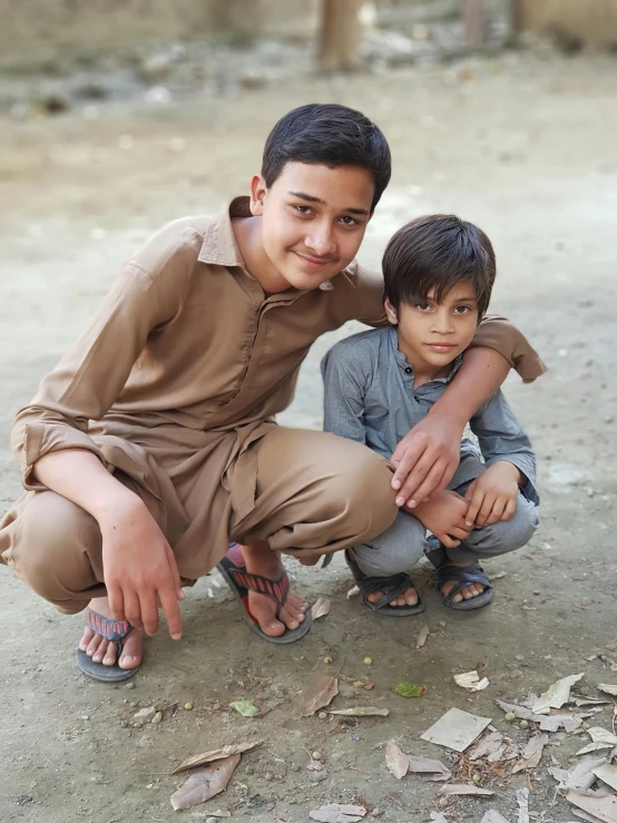 two boys pose for the camera in their matching clothes