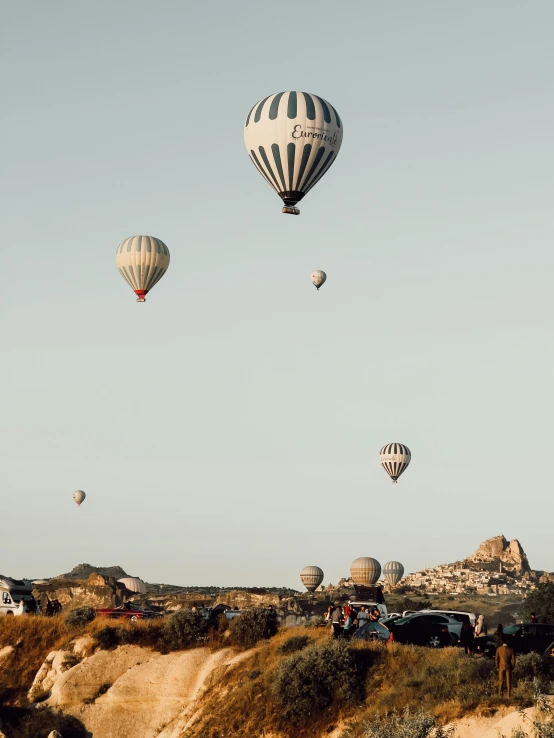 a group of  air balloons floating above a field