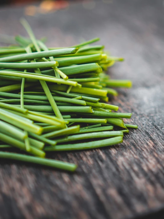 green beans piled up on top of a wooden board