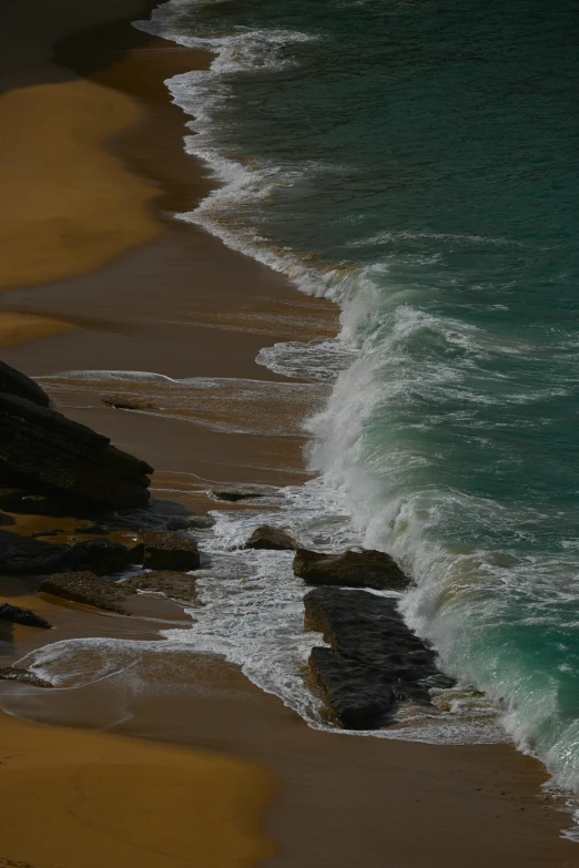 a surfer carrying a surfboard and walking to the ocean