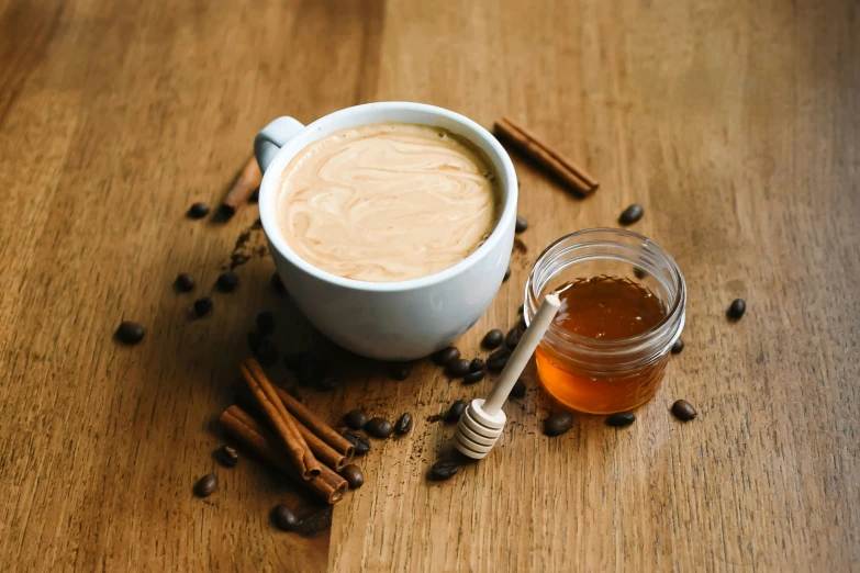 a mug of coffee and cinnamons sitting on a table