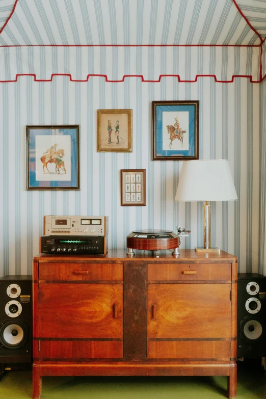 a lamp, stereo, and wall hanging on a wall