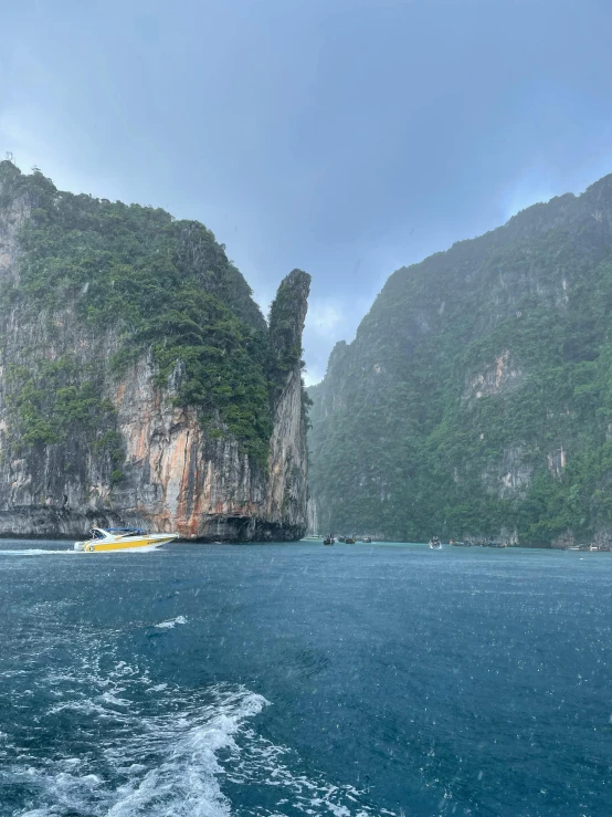 boats sit in a body of water surrounded by tall mountains