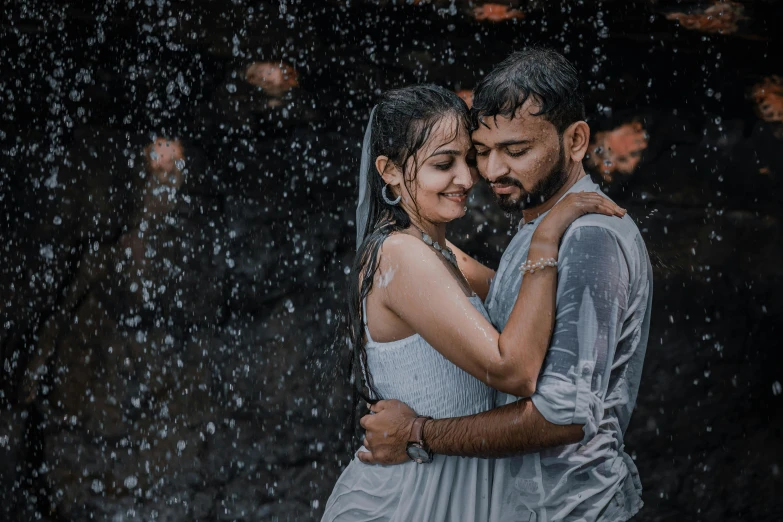 the young couple is standing under the rain